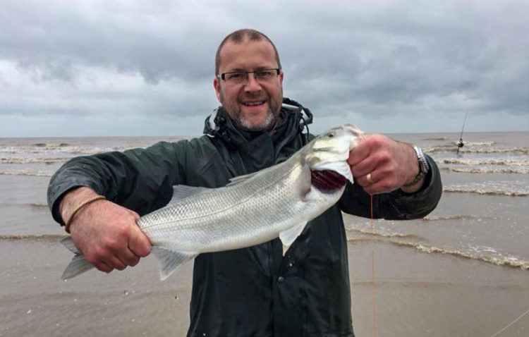 Paul Brown with a bass caught at low water