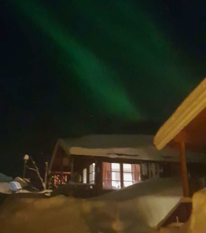 Northen lights over the wooden cabin