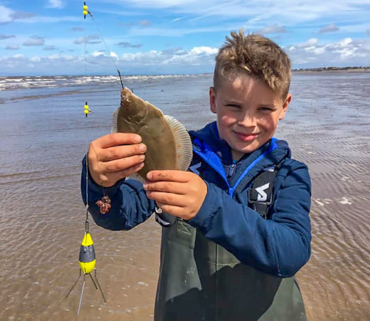 8 year old Archie Baxter with a plaice he caught at low water